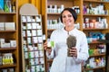 Woman with bunch of dried herbs in drugstore