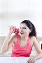 Woman with a bunch of grapes in kitchen Royalty Free Stock Photo