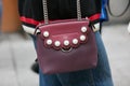 Woman with burgundy Fendi leather bag before Emporio Armani fashion show, Milan Fashion Week