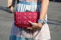 Woman with burgundy leather bag, Rolex watch and bracelets before Dsquared2 fashion show, Milan