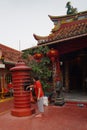 a woman is burning paper as a series of worship at a pagoda in the city of Tangerang January 15, 2022