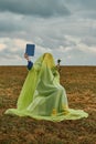 Woman in burqa on chair in field with white rose in her hands is reading book. concept