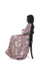 Woman with burqa and flowered dress sitting Royalty Free Stock Photo