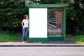 Woman at a bus stop blank billboard Royalty Free Stock Photo