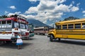 Woman in a bus terminal with colorful buses in Antigua, Guatemala