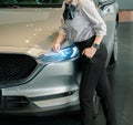 Woman business saleman with car in showroom office blurred background.For automotive automobile or transport transportation image.