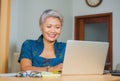 Lifestyle portrait of Happy and attractive elegant middle aged Asian business woman working smiling at office computer desk Royalty Free Stock Photo