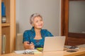 Lifestyle portrait of Happy and attractive elegant middle aged Asian business woman working smiling at office computer desk Royalty Free Stock Photo