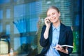 Woman in business suit carries folder with documents and smiles while talking Royalty Free Stock Photo