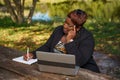 Woman in business teleworking in the park with laptop computer