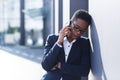 Woman businessman sad complains on the phone, reports bad news, African American woman in despair near the office, holding hands Royalty Free Stock Photo