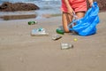 Woman busy collecting rubbish, holds garbage bag