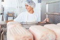 Woman in butchery processing meat