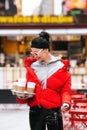 Woman buy coffee on Time Square New York. Urban view of trendy female in stylish glasses in downtown Royalty Free Stock Photo