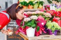 Woman buyer selects and smells bouquets before buying at a flower shop on the street Royalty Free Stock Photo