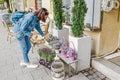 Woman buyer selects and smells bouquets before buying at a flower shop on the street Royalty Free Stock Photo