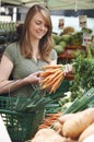 Woman Buying Carrots At Market Vegetable Stall