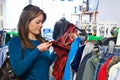 Woman Buying Children's Clothes In Charity Shop