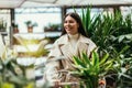 Woman buying flowers pushing shopping cart in garden center Royalty Free Stock Photo