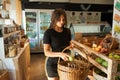 Woman Buying Fresh Fruit And Vegetables In Sustainable Plastic Free Grocery Store