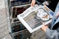 Woman buying German Die Zeit newspaper with Angela Merkel Royalty Free Stock Photo