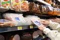 Woman buying Great Value store brand sliced cooked ham