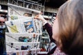 Woman buying international press with Emmanuel Macron and Marine