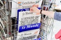 Woman buying Le Monde newspaper with shocking headline about Br