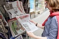 Woman buying LIBERATION newspaper with shocking headline about