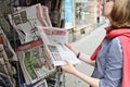 Woman buying LIBERATION newspaper with shocking headline about