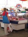 A woman buying meat for sale in the Komarovsky marketplace, Minsk Belarus