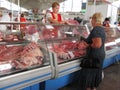 A woman buying meat for sale in the Komarovsky marketplace, Minsk Belarus