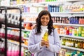 Woman buying new oil in hair care store Royalty Free Stock Photo