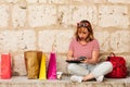 Woman buying online from her mobile device or tablet with her credit card in the street. lifestyle concept. colored bags and Royalty Free Stock Photo