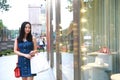 Happy Asia Chinese Eastern oriental young trendy woman girl shopping in mall with bags look at shopping window on street city Royalty Free Stock Photo