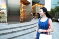 Happy Asia Chinese Eastern oriental young trendy woman girl shopping in mall with bags shopping window background on street city Royalty Free Stock Photo