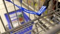 Woman buying Red Bull sugarfree energy drink and putting into shopping cart