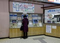 A woman buying tickets at the train station in Takayama, Japan