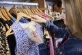 Young Woman Buying Used Sustainable Clothes From Second Hand Charity Shop Looking At Price Tag