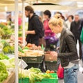 Woman buying vegetable at local food market.