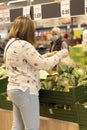 Woman buying vegetables in the supermarket wearing gloves