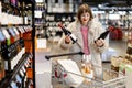 Woman buying wine at supermarket Royalty Free Stock Photo