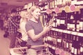 Woman buying wine in supermarket Royalty Free Stock Photo