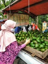 A woman buys avocados for sale in a pickup.