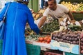 Woman buys fresh fruits and vegetables from Brixton Market, South London, UK