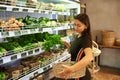 Woman Buying Fresh Fruit And Vegetables In Sustainable Plastic Free Grocery Store