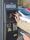 Woman buys a ticket at a parking meter Royalty Free Stock Photo