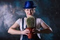 Woman with a cactus in her hand. The thorny plant is the symbol of the year. Long dangerous needles. Flower pot Royalty Free Stock Photo