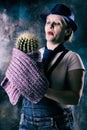 Woman with a cactus in her hand. The thorny plant is the symbol of the year. Long dangerous needles. Flower pot Royalty Free Stock Photo