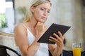Woman in cafe looking at tablet pc